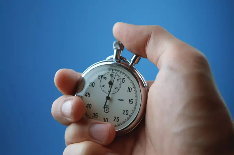 close up de uma mão segurando um cronômetro