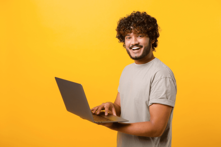 Jovem rapaz sorridente com um notebook na mão fazendo o onboarding digital