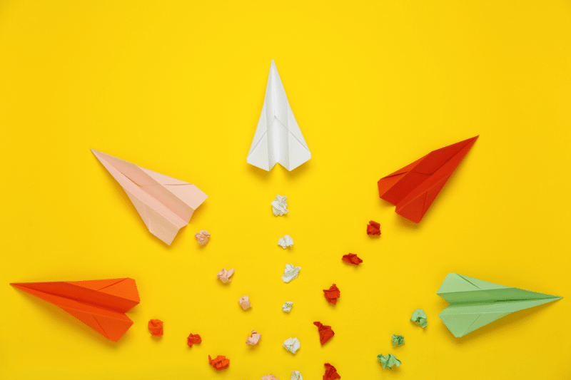 Diferentes aviões de papel representando os diferentes tipos de liderança.