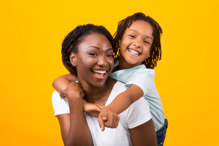 Mãe sorrindo em um fundo amarelo de estúdio. Representação do dia das mães na empresa