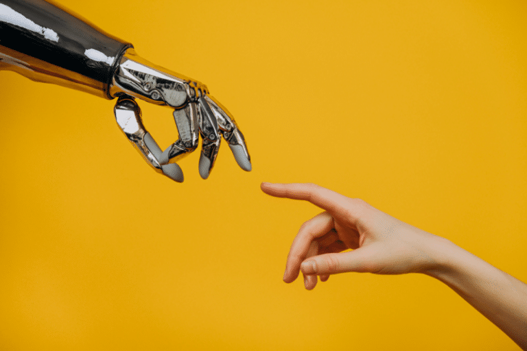 Mão de um robô e de um humano representando a inteligência artificial no recrutamento e seleção