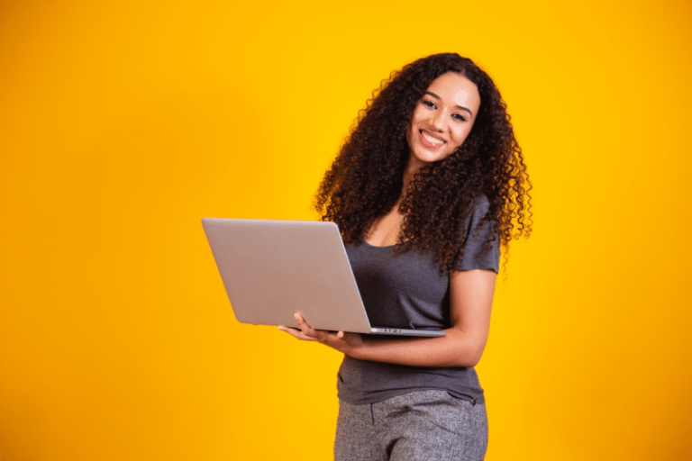 Mulher segurando notebook para representar como conduzir uma pesquisa de clima em empresas tech