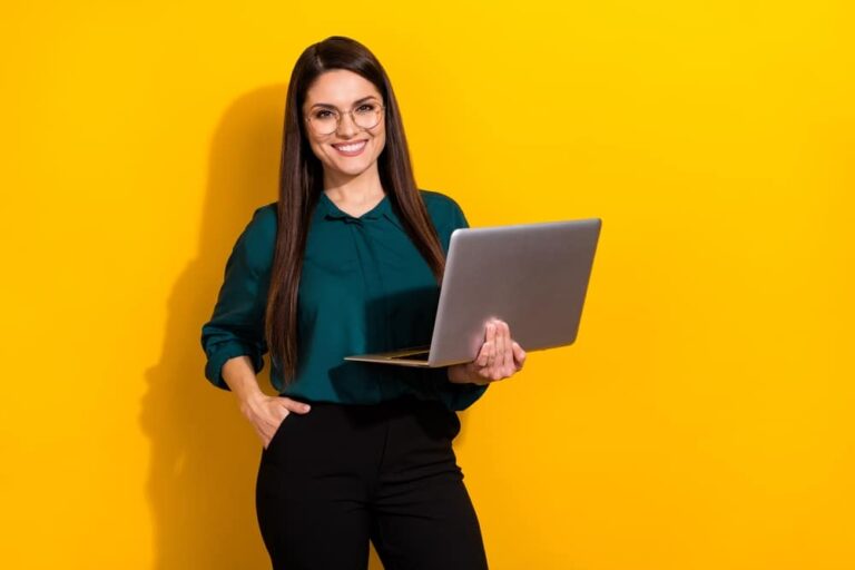 Mulher com um notebook na mão representando o conceito de Como orientar os colaboradores a realizar a autoavaliação de desempenho