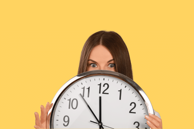 mulher segurando um relógio, fazendo alusão ao tema limites de horas extras